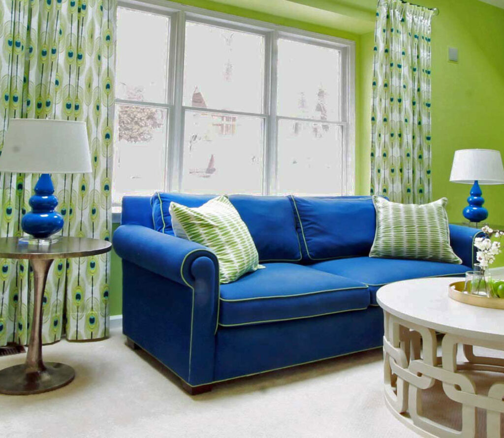 INterior design project featuring bold green walls with blue accent sofa