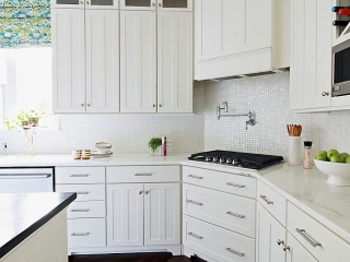 kitchen design with mother of pearl tile, white cabinets, custom cabinets and range hood, potfiller and hardwood floors on the main line philadelhpia