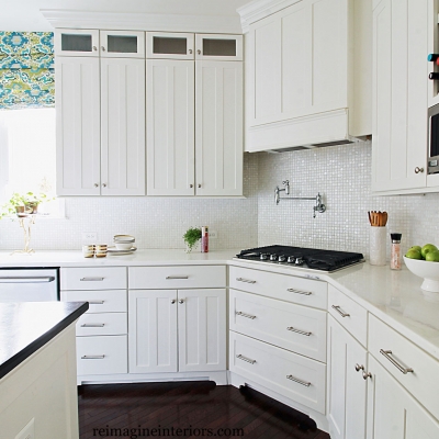 kitchen design with mother of pearl tile, white cabinets, custom cabinets and range hood, potfiller and hardwood floors on the main line philadelhpia