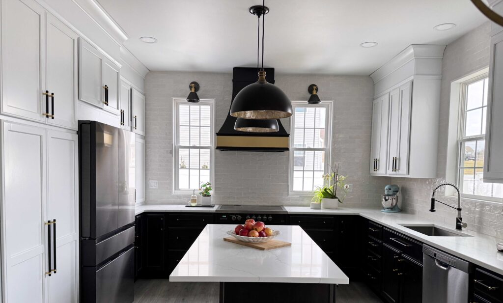 Two tone kitchen design, black and gold accents, windows, backsplash