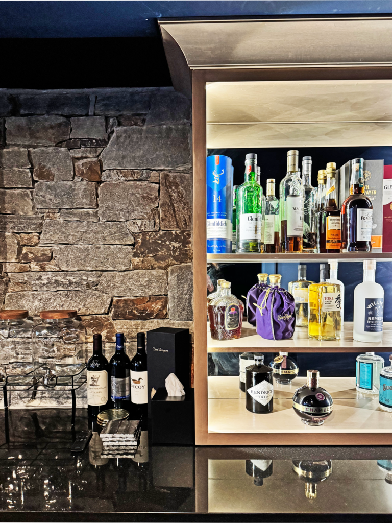 Warm contemporary basement bar with seating for guests and built-in drink station, moody country club feel