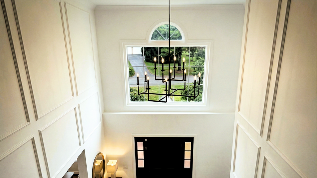 two story foyer with custom picture frames moldings and modern chandelier in West Chester