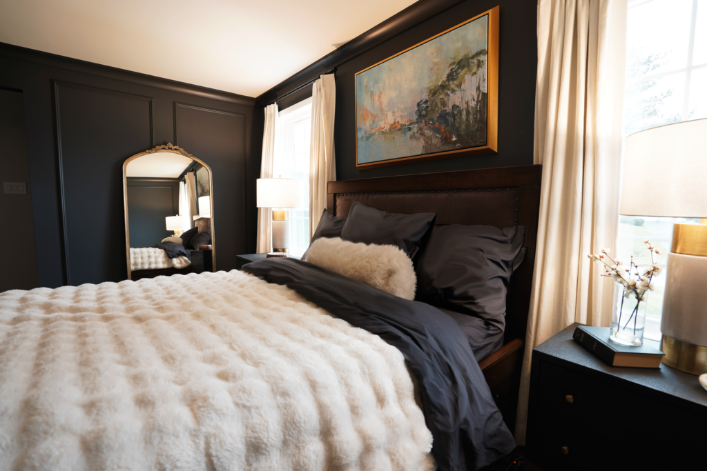 Warm contemporary bedroom with dark walls and layered bedding