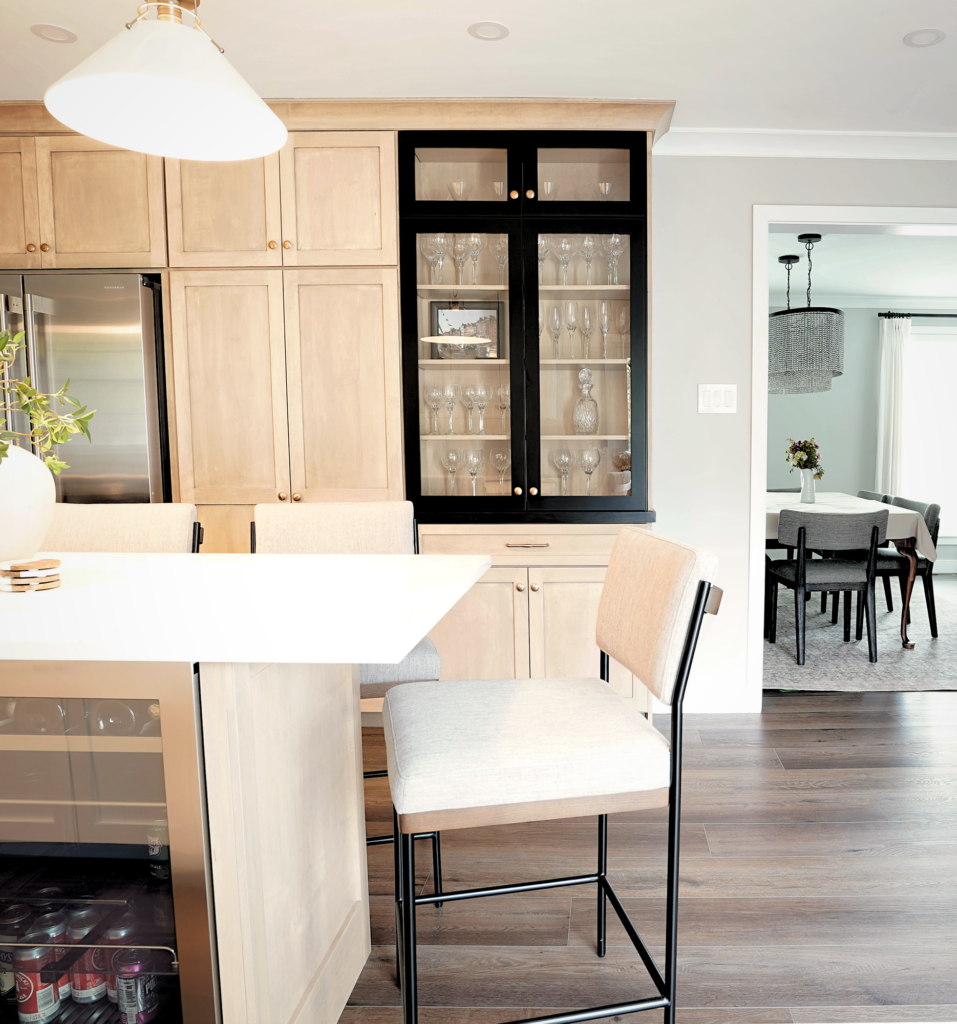 Black glass cabinet display integrated into warm wood kitchen cabinetry.